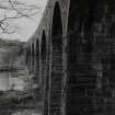 Detailed view from SSW along S side of viaduct, with masonry arches and piers in foreground
