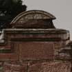 Detail of pediment above niche on outside of north wall.