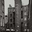 View from South showing rear of tenements and staircase tower.