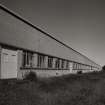 General view of S side of factory from WSW, which is built from different phases of matching yellow brick