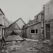 View from East of (R-L) former mechanics' shop and East end of South range of Weaving Room.