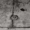 Detail of exposed cast-iron column lug (0.11m diameter) protruding from flagstones of the Second Floor of the Mill. This floor was exposed when a fire destroyed the roof and Double Attic.