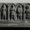 Figured sculptured slab beside the door of the 19th-century church; panel of weepers from a table-tomb in the N wall of the S porch