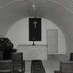 Interior view of church showing harmonium, altar and seating (hut 21)