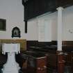 Interior. Detail of pews and octagonal stone font