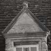 Detail of inscribed pediment of dormer window of old house.