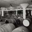 Blending Hall: View from SW on ground floor showing wooden casks of blended whisky in foreground and three large blending vats.
Photographed 27 January 1994