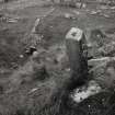 Oblique view of rear of cross-marked stone, number.3, with settlement site in background, on Isle of Pabbay.