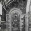 Interior. North chapel, view of mural on east wall and stained glass window.