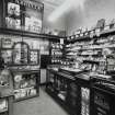 View of interior of tobacconists shop from SW showing display cases, counter and weighing scales