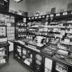 View of interior of tobacconists shop from W showing display cases, counter and weighing scales
