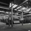 Interior. General view within Broadloom Weaving Department, showing rows of broad looms (many with 20-foot beams).  These were part of the Paper Trade Products section, and produced wire cloth much of which was used to produce calender drums for paper making machines