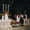 Interior.
View of choir and apse ended chancel with director of music conducting choristers.