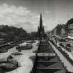General view of Princes Street looking West with Scott Monument in centre of photograph and also showing trams, cars and awnings on shop fronts