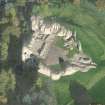 Oblique aerial view of Kildrummy Castle centred on the remains of the castle, taken from the S.