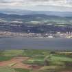 Oblique aerial view looking across River Tay and railway bridge towards the City of Dundee and Grampian mountains, taken from the SE.