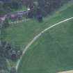 Oblique aerial view centred on the cropmarks of the country house with cathedral adjacent, taken from the NNE.