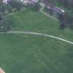 Oblique aerial view centred on the cropmarks of the country house with cathedral adjacent, taken from the NNW.