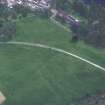 Oblique aerial view centred on the cropmarks of the country house with cathedral adjacent, taken from the NW.